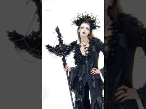 Close-up details of raven cross staff ornament with metal chains and ruffled fabric textures