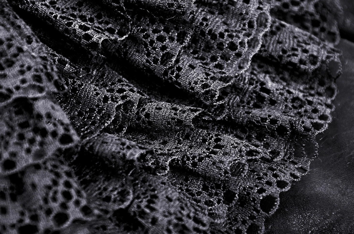 Intricate close-up of black floral lace trim and ruffled layers on steampunk gothic mini skirt