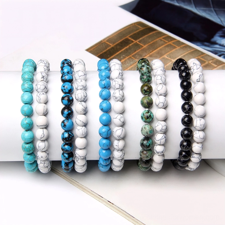 Four color variants of natural stone beaded bracelets displayed together, showing turquoise, green, blue, and black options, collection display