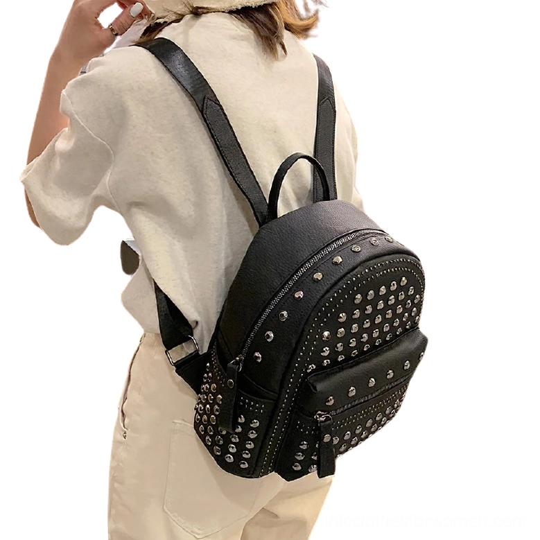 Women wearing black rivet backpack side view with adjustable leather shoulder strap and alternative fashion styling