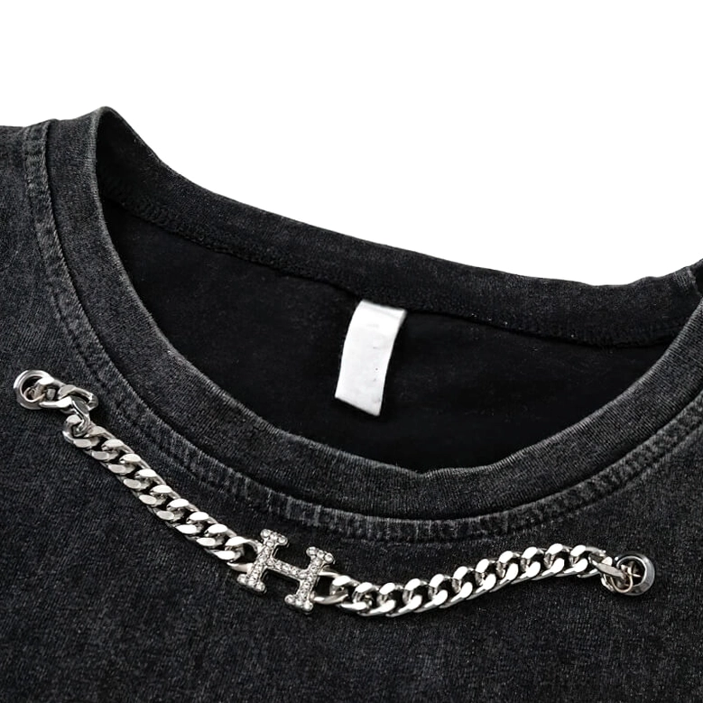 Close-up detail of crew neckline with attached silver curb chain and rhinestone cross charm on gothic tank top