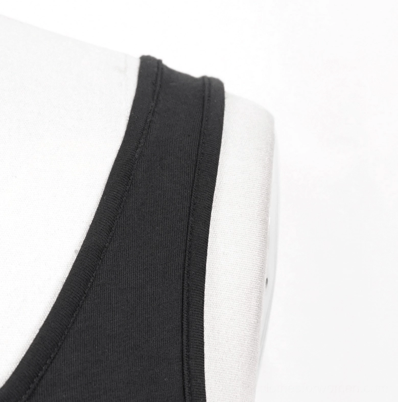 Close-up neckline detail of black gothic spike tank top showing finished bound neckline and smooth fabric trim finish