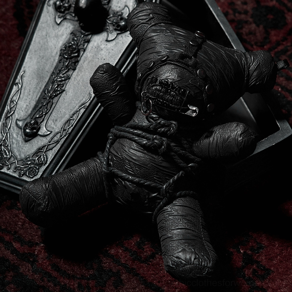 Gothic rope-bound teddy bear plush displayed on dark red velvet with coffin prop - dramatic dark aesthetic