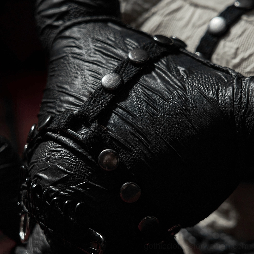 Close-up detail of gothic teddy bear harness with metal round studs, bondage straps, and textured black fabric
