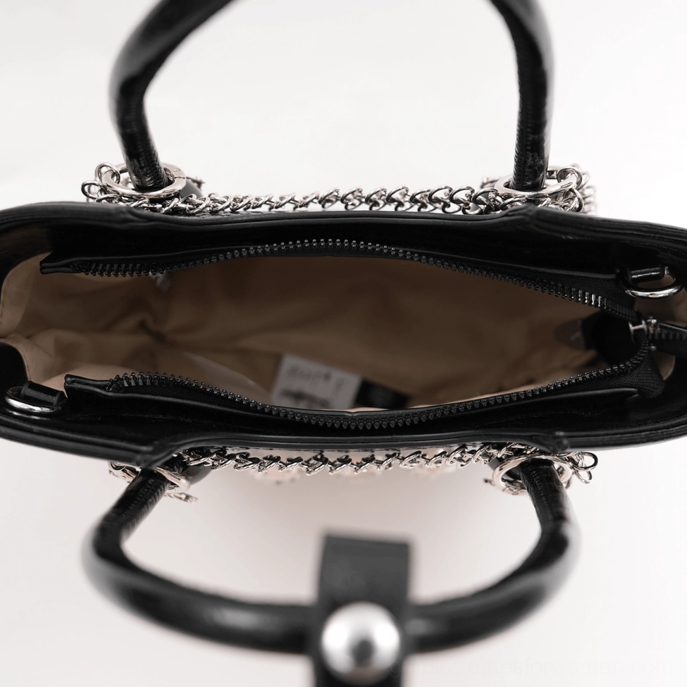 Close-up detail of black gothic tote bag interior zippered compartment and reinforced leather handle with chain trim