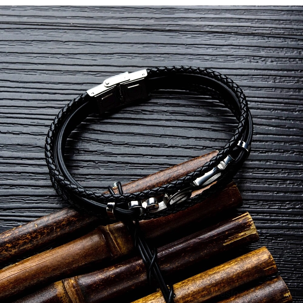 Black leather treble clef bracelet top-down flat lay on bamboo and dark wood surface double-layer structure
