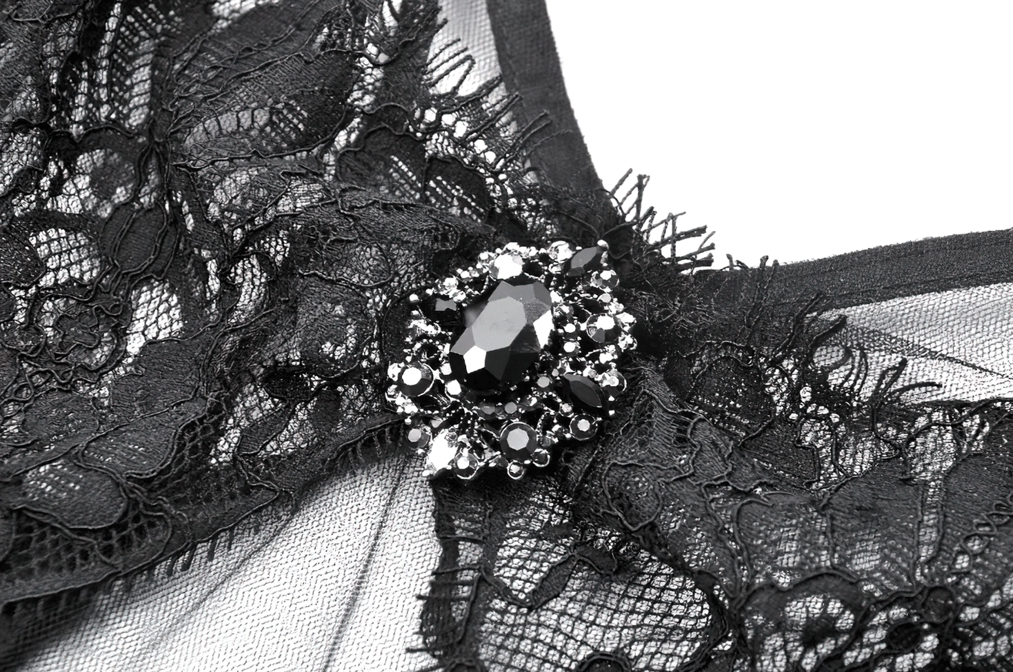 Detailed macro photography of black gothic dress floral lace pattern with rhinestone gem accent