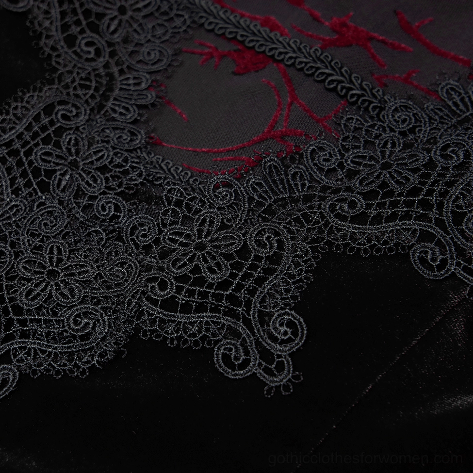 Close-up of black floral lace neckline trim with red mesh fabric detail on gothic velvet dress