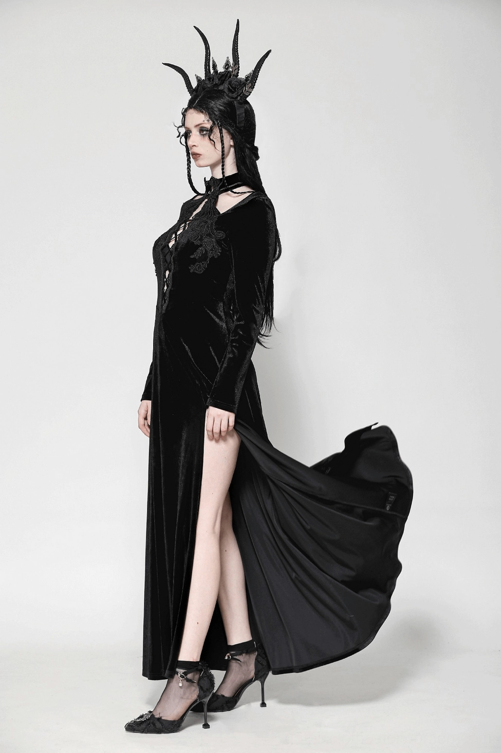 Side view detail of gothic velvet dress displaying asymmetrical thigh-high slit and fitted slim silhouette