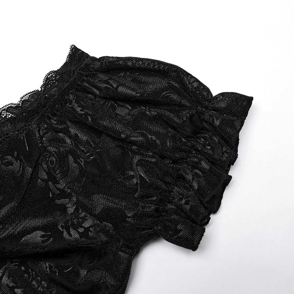 Close-up detail of black velvet gothic dress sleeve trim showing ruffled lace edge and floral jacquard fabric texture