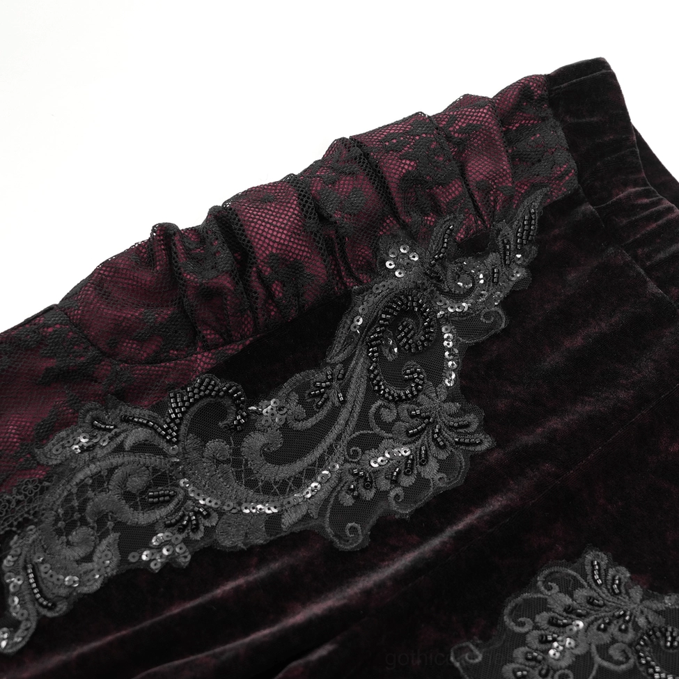 Black velvet and wine-red lace gothic flare pants displaying embroidered hip detail and high-waisted silhouette from front angle