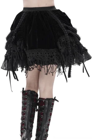 Gothic velvet skirt back view showing tassel fringe hem and lace trim details, model wearing combat boots