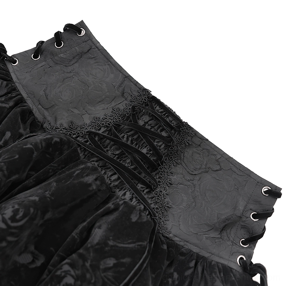Close-up detail of black gothic velvet skirt front corset closure showing lace-up corset waist, embossed velvet waistband, and decorative matching trim