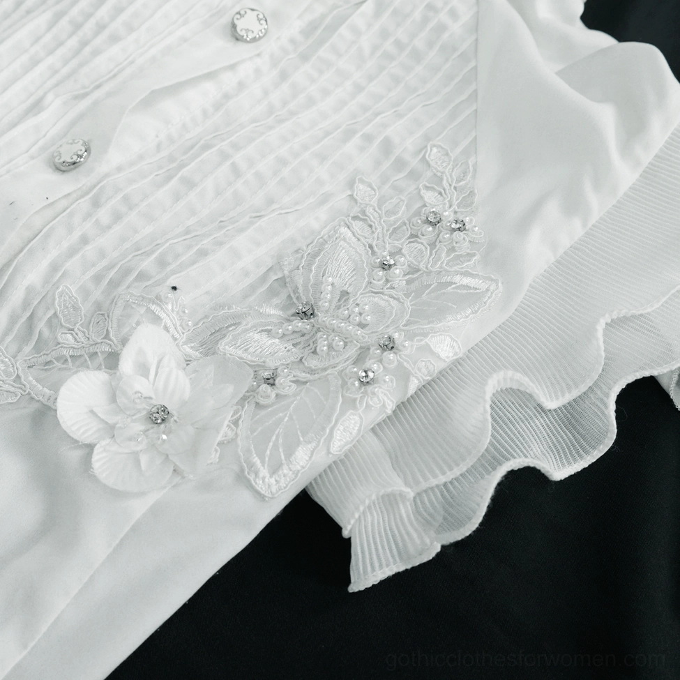 Detail view of white gothic blouse ruffled cuff and lace-up closure mechanism