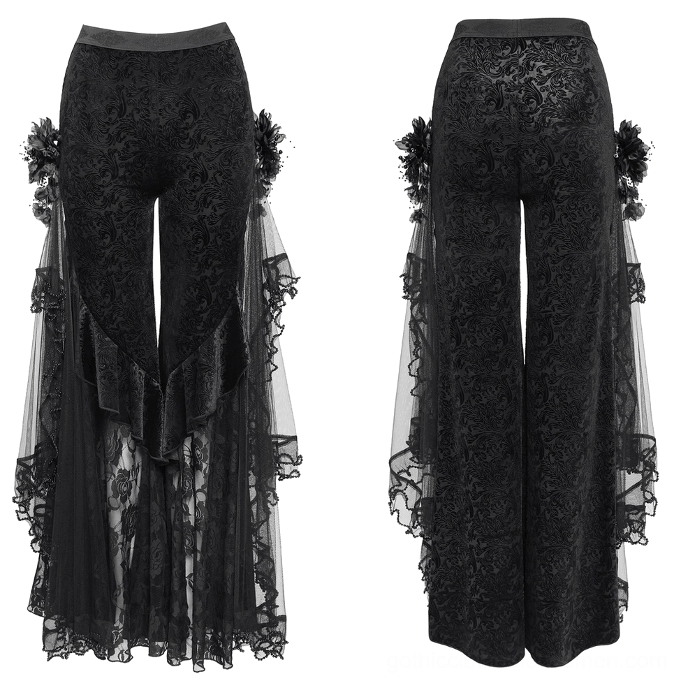 Black gothic wide leg pants flat lay showing asymmetrical lace ruffles and ornate side flower embellishments