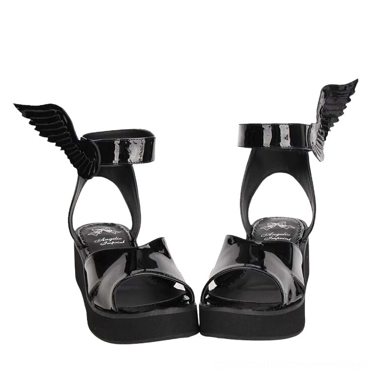 Pair of black patent leather winged sandals front flat view showing both shoes with sculptural wing ankle ornaments and open-toe design