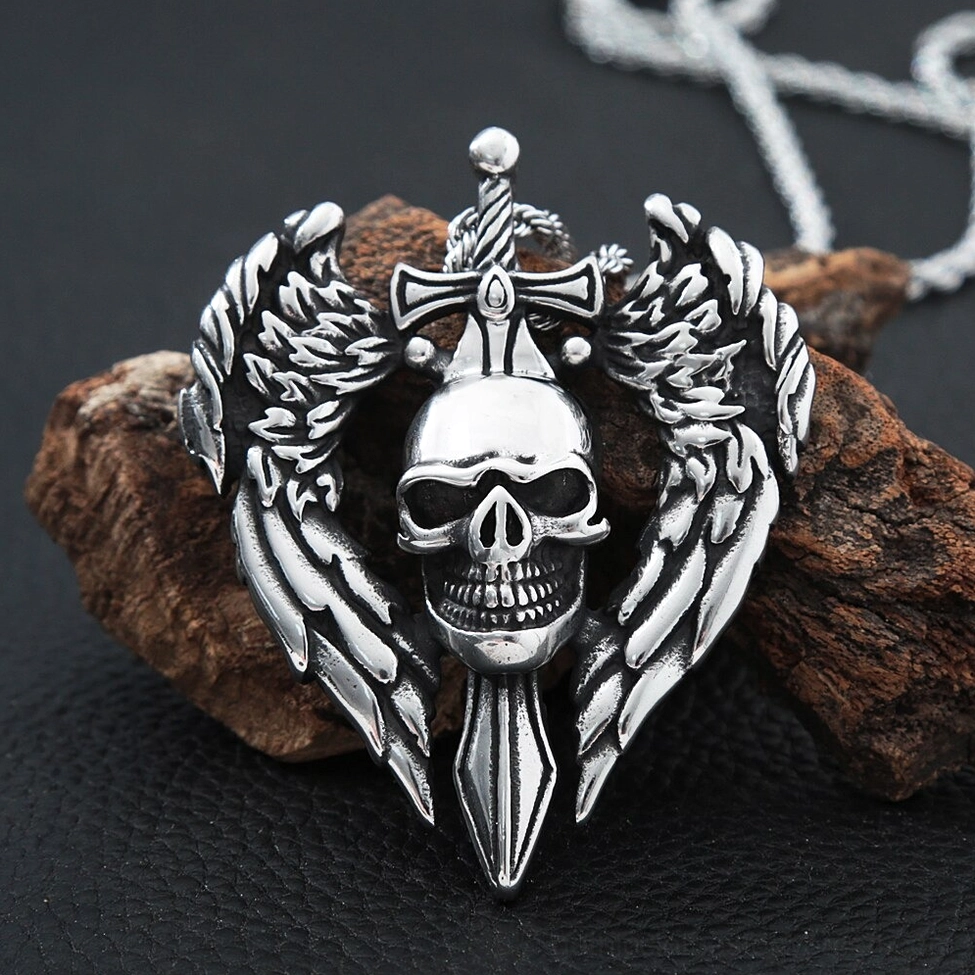 Winged skull pendant necklace with distressed antique silver finish on rough wooden block background