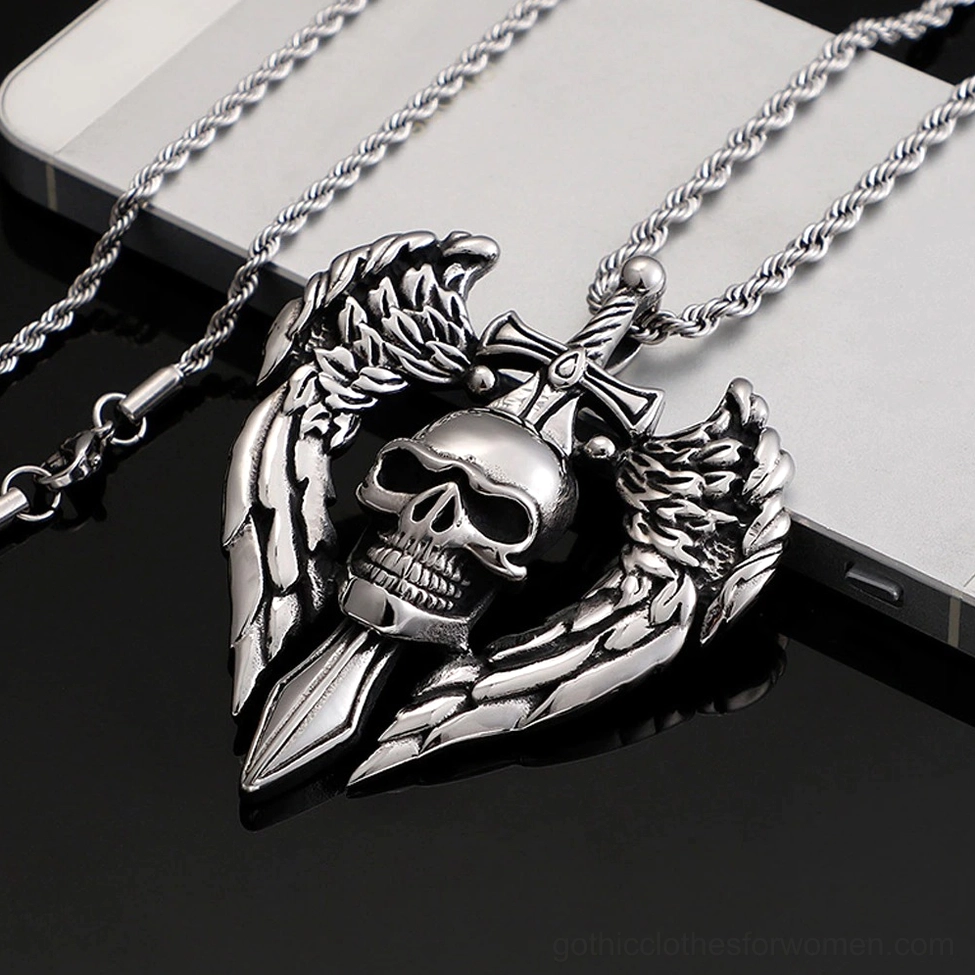 Oblique side view of gothic winged skull pendant on smartphone surface showing three-dimensional profile and sculptural depth
