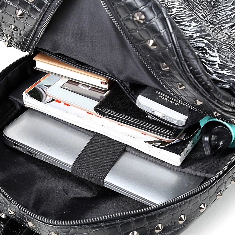 Gothic wolf backpack interior compartment showing laptop storage strap, studded croc exterior, and functional pockets
