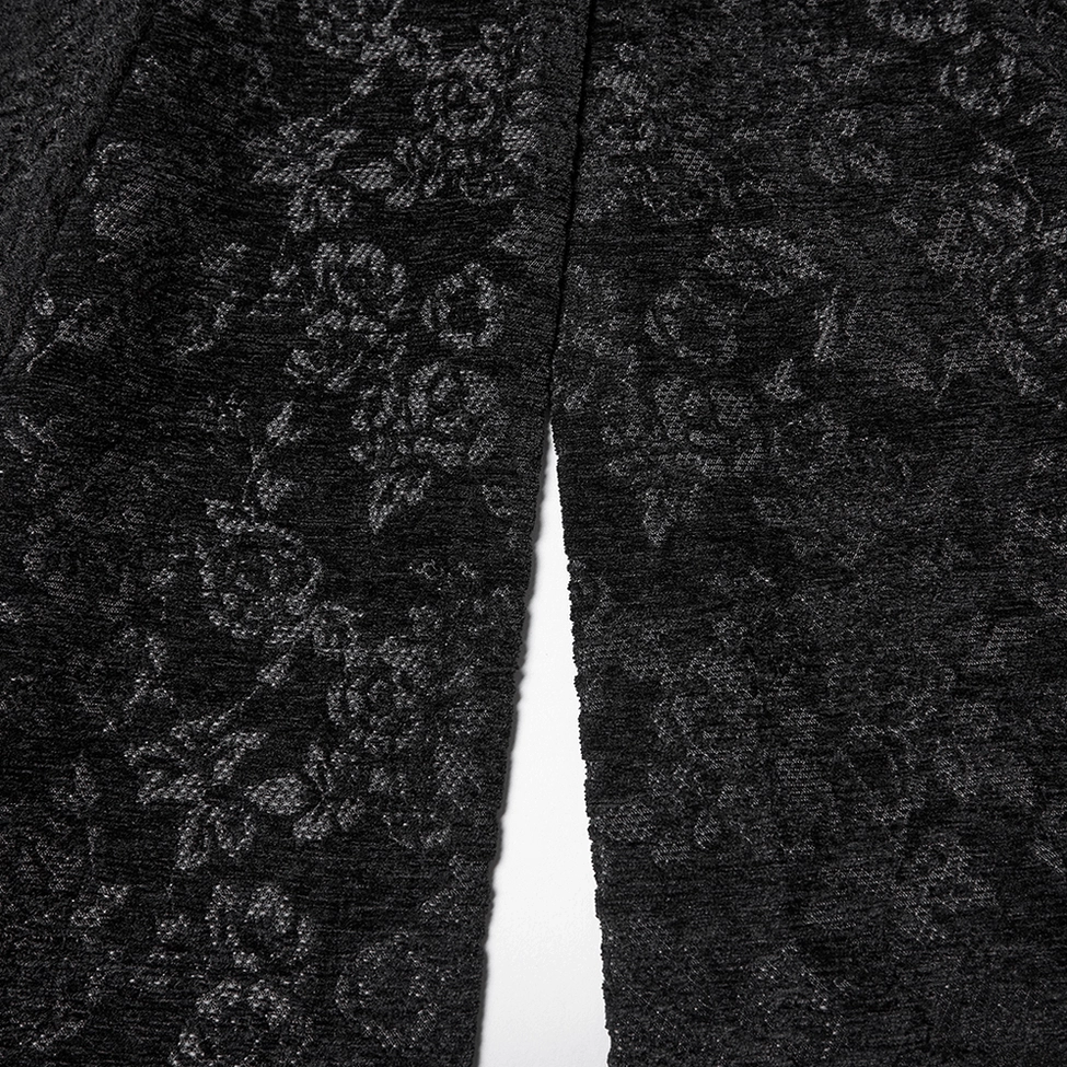 Close-up fabric texture detail of black gothic wool coat showing floral jacquard pattern and premium fuzzy woolen weave composition