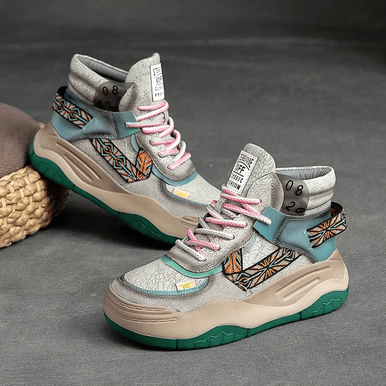 Light gray gothic platform patchwork boots front static display with woven cushion prop, showing green platform sole and leather patchwork