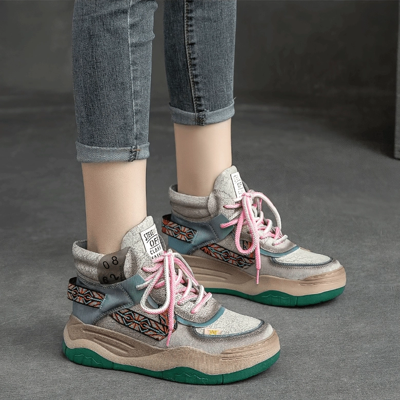 Light gray gothic platform boots styled with rolled-up denim jeans, side studio view of platform sole and lace-up closure