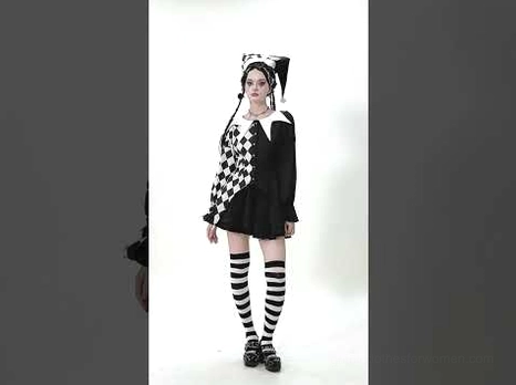 Flat lay studio shot of black white harlequin jester hat showing lace trim and pompom details