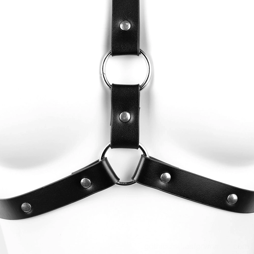 Overhead close-up view of dual metal O-rings and riveted black PU leather straps showing harness cage structure and precision construction