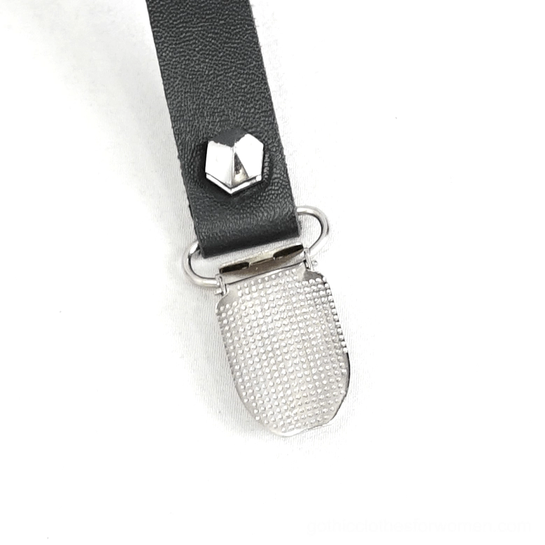 Macro close-up of heart-shaped metal stud and textured metal clip on gothic garter showing craftsmanship detail