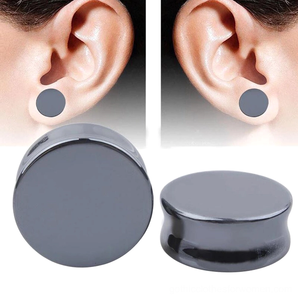 Dark gray hematite flesh tunnel plug worn in ear, side profile view showing gothic aesthetic and smooth polished stone texture in real wear situation