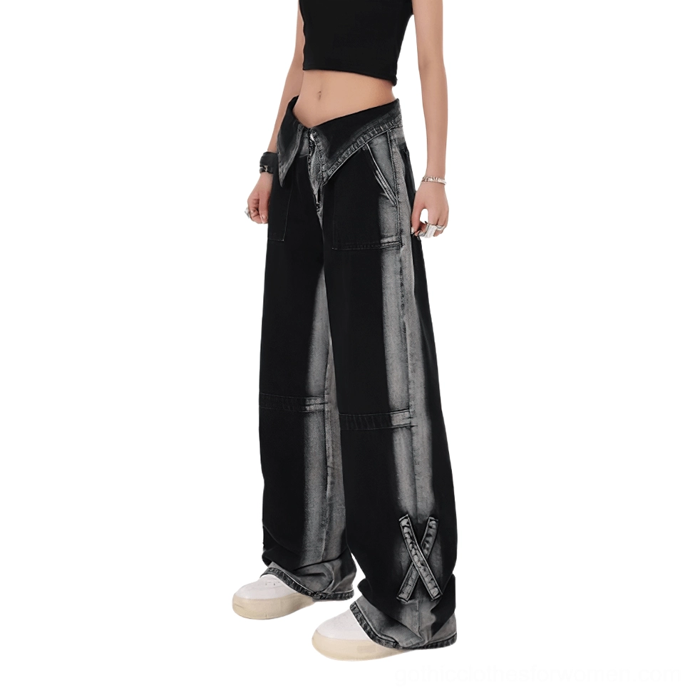 Partial side view of high-waist black denim jeans showing folded lapel waistband and faded black wash