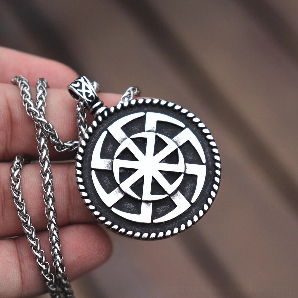 Kolovrat pendant held between fingers - clear front wheel pattern display on chain
