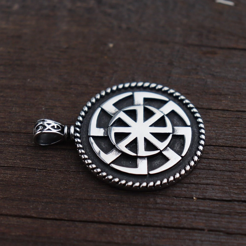 Kolovrat pagan pendant on wooden background - angled view showing silver and black finish