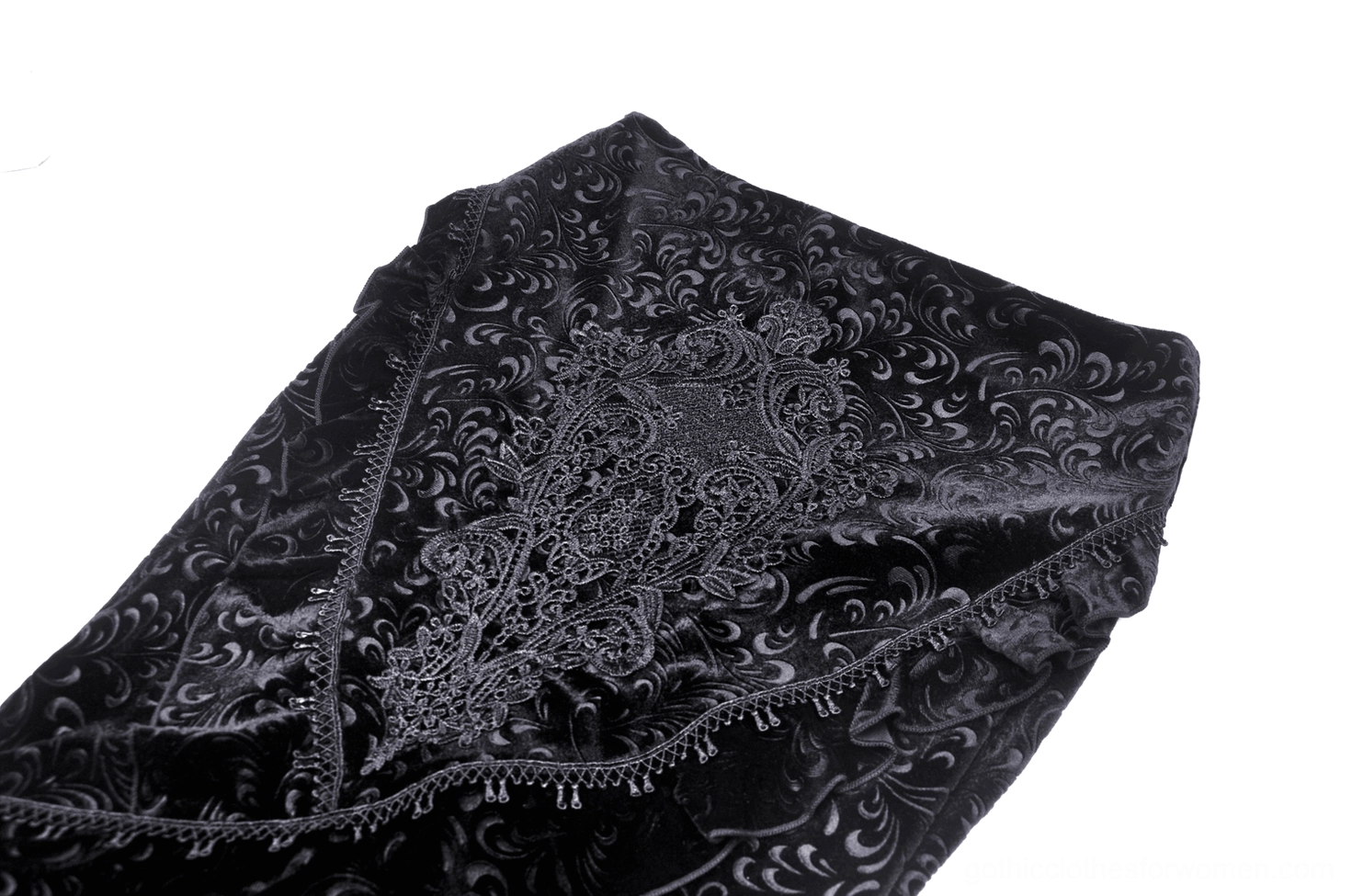 Close-up detail of intricate lace embroidery on black velvet with beaded edge trim and baroque patterns