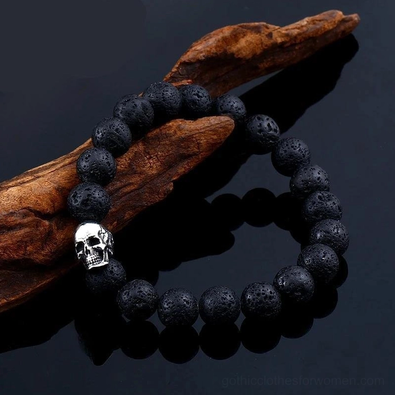 Close-up lava stone skull beaded bracelet - textured volcanic beads with silver skull accent on black surface