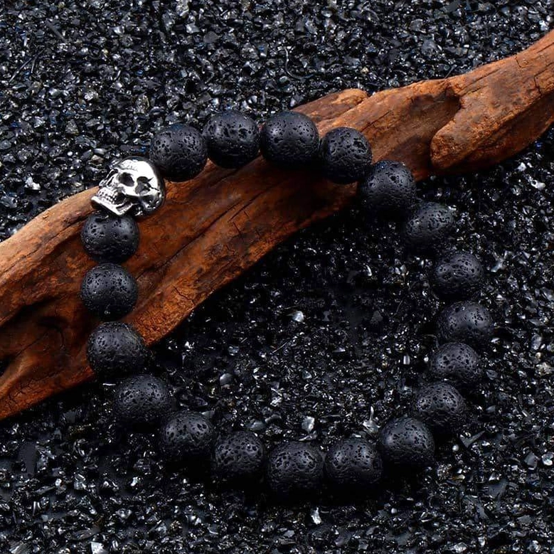 Lava stone skull bracelet detailed view - matte black volcanic beads, vintage silver skull charm on natural backdrop