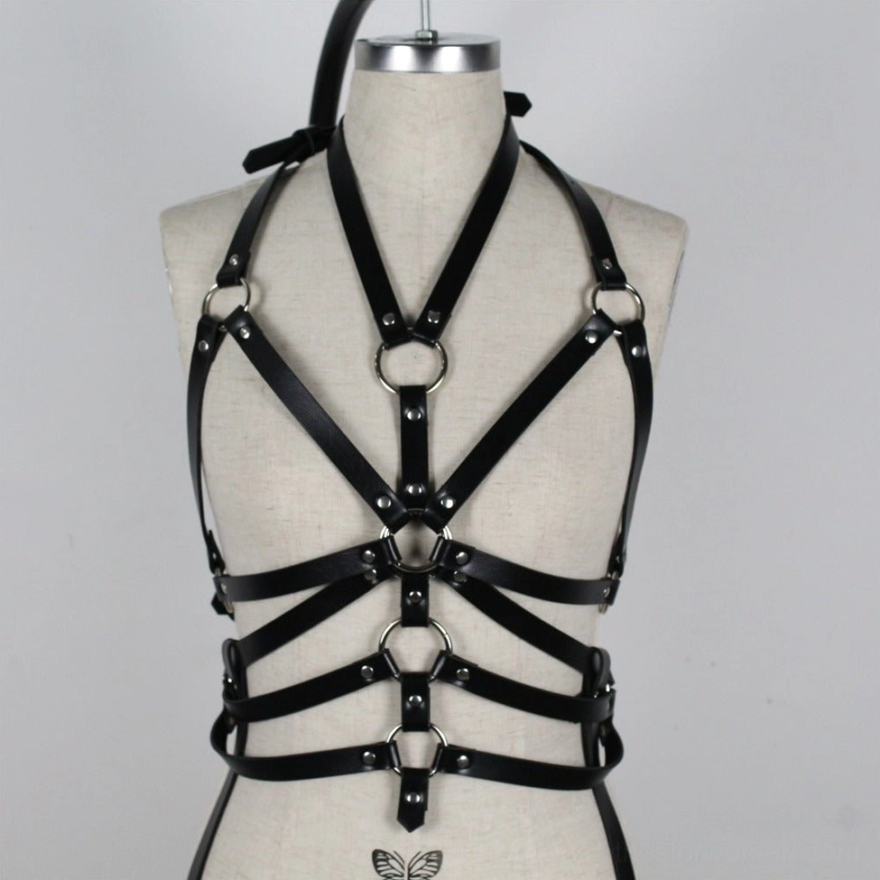 Black bondage harness worn as layered fashion piece with sheer mesh top demonstrating versatile styling for alternative fashion lovers