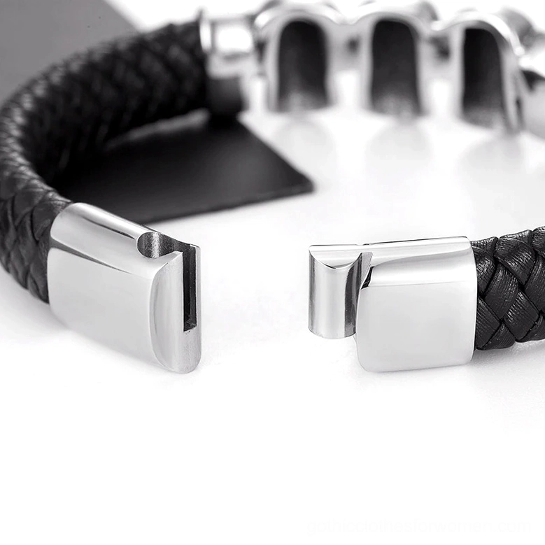 Close-up detail of black leather braided skull bracelet showing stainless steel magnetic clasp and triple skull metal charms