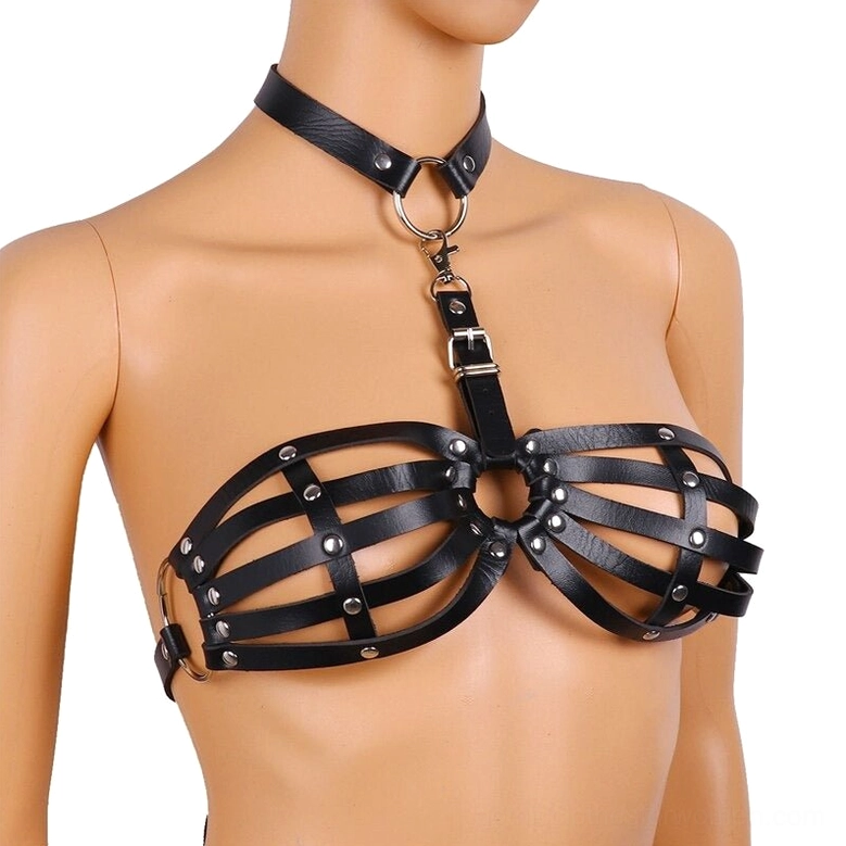 Side front view of black leather harness on mannequin, showing side buckle fasteners and angular cage bra structure with industrial metal details
