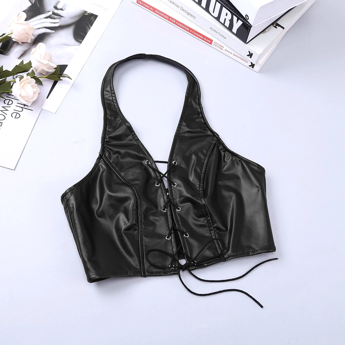 Black faux leather lingerie set featuring halter crop top with prominent lace-up front and coordinating thong