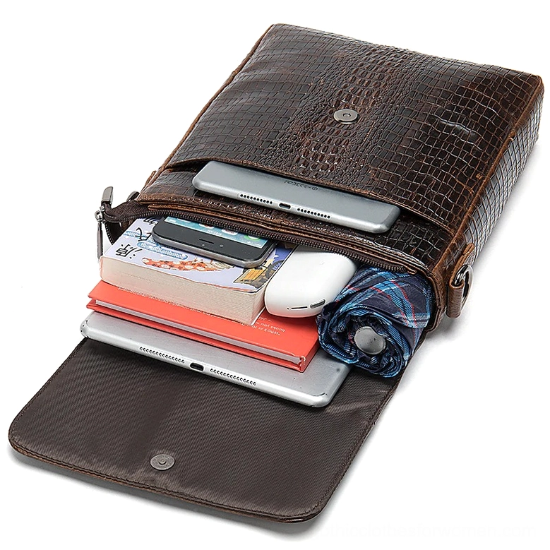 Opened genuine leather messenger bag flat lay view with daily gadgets, books, and stored items demonstrating storage capacity and functionality