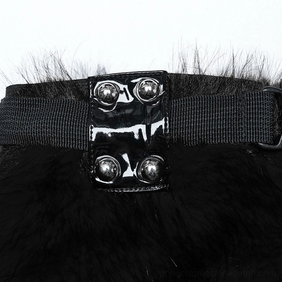 Close-up macro view of gothic leg warmer buckle hardware showing patent leather base with four semi-circular rivets and elastic webbing attachment