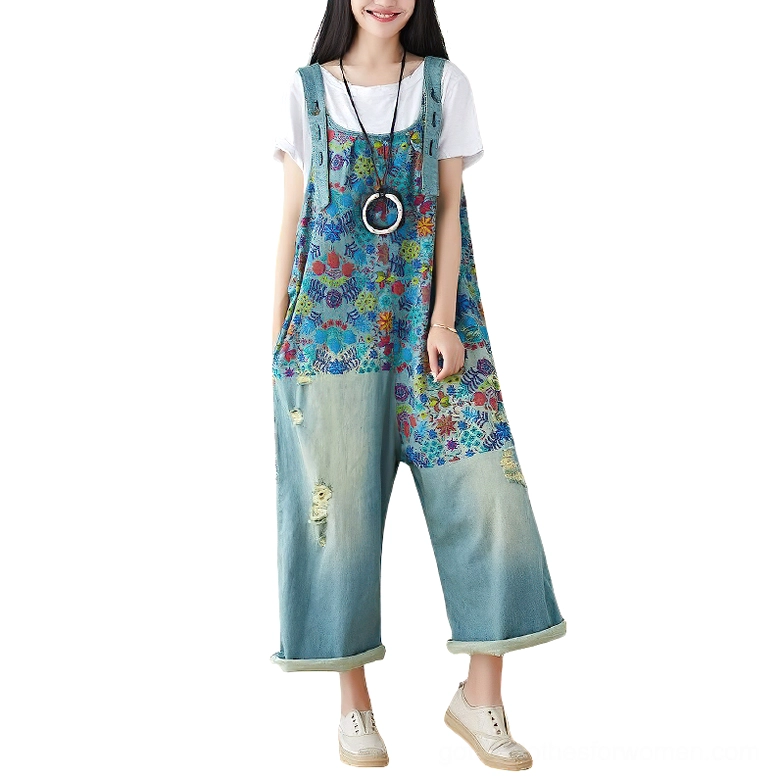 Light blue floral denim wide-leg overalls worn by model, front full view with rolled cuffs and layered styling, showcasing the botanical print and relaxed silhouette