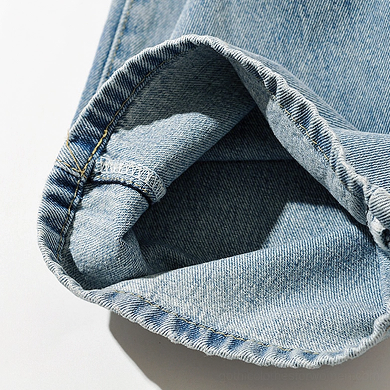 Light blue gothic denim jeans back pocket detail and waistband belt loop integration on washed fabric