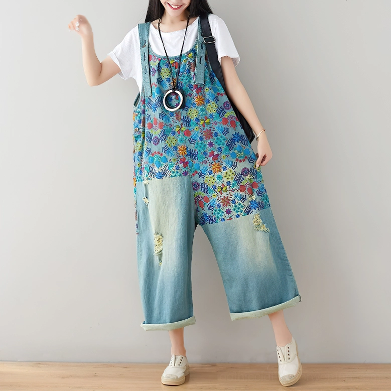 Light wash distressed floral denim overalls front view, worn with white short-sleeve top, showcasing romantic gothic styling approach