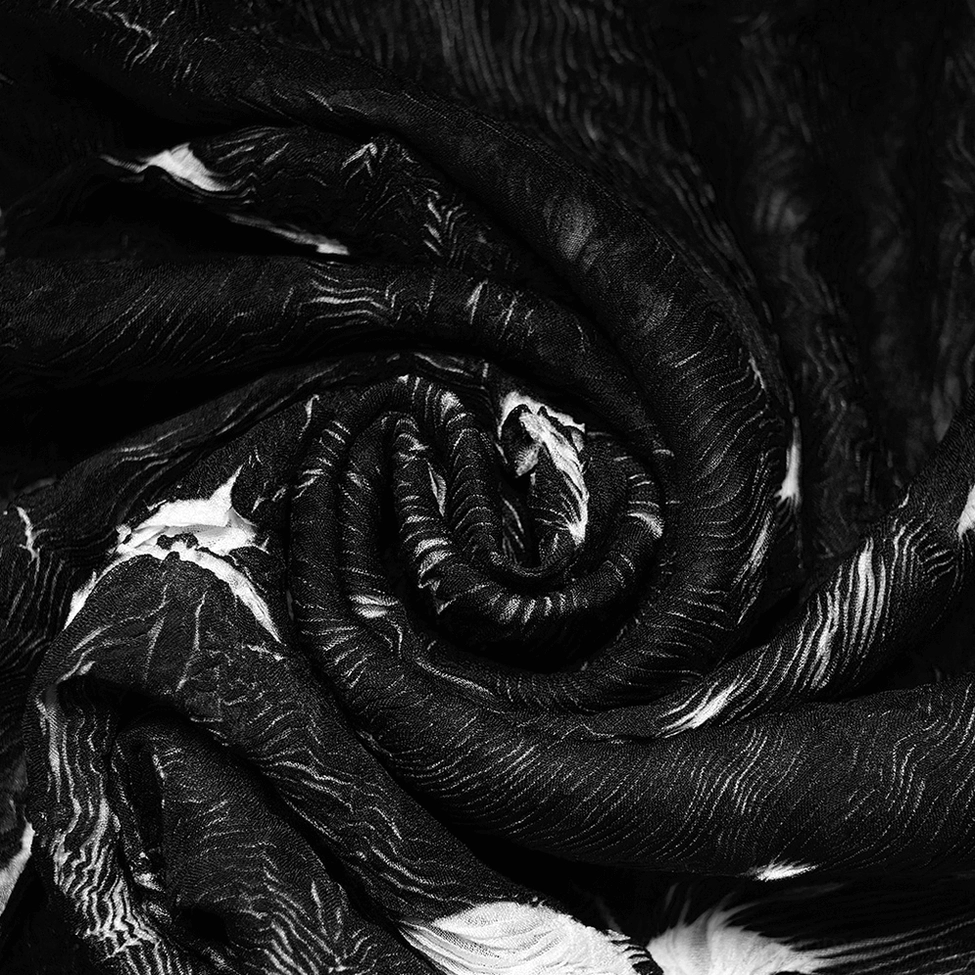 Overhead close-up of swirled marble texture on wrinkled woven polyester fabric of gothic long-sleeve fitted top