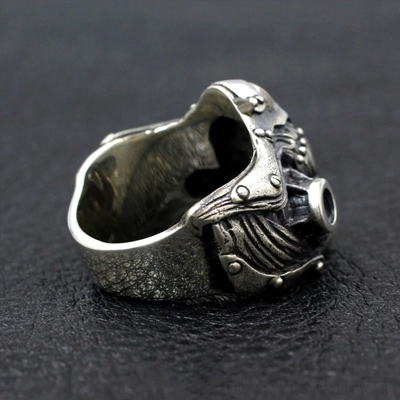 Sculptural gas mask ring interior view with band construction on black leather background