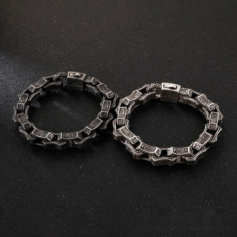 Pair of matching vintage gothic engraved chain bracelets with antique silver finish and intricate carved patterns overhead view