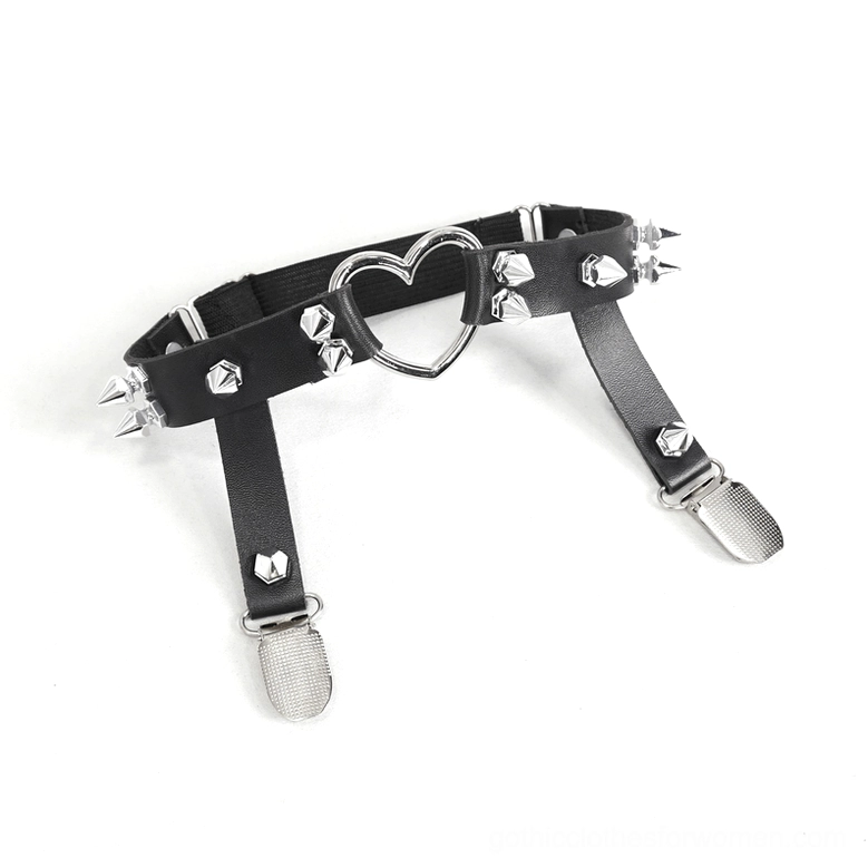 Flat lay close-up detail of metal heart garter strap with black leather backing, rivet studs, and dual fixing clips