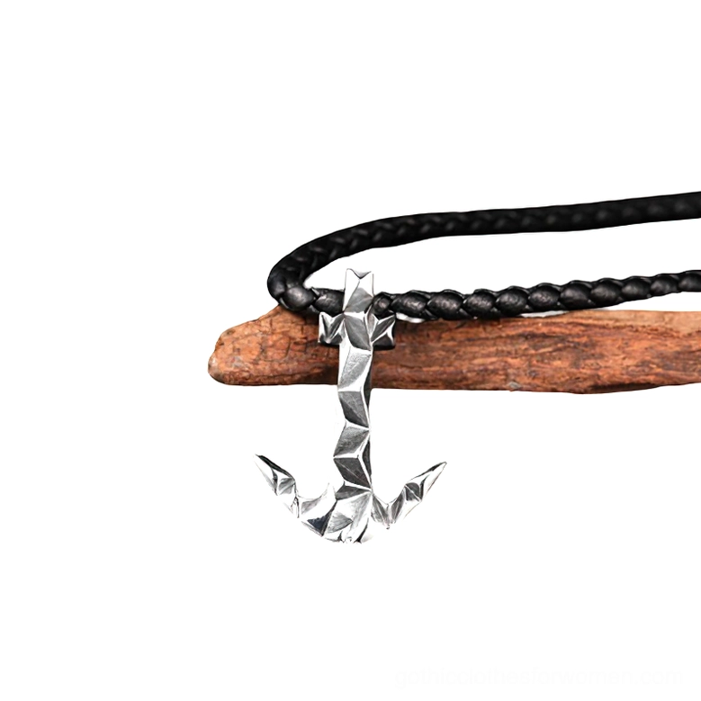 Compact silver stainless steel anchor charm pendant on black braided cord, side profile flat lay, miniature gothic necklace detail